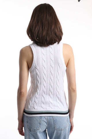 The back of a model wearing white cable knit sweater tank top with blue white and black stripe detail on bottom hem