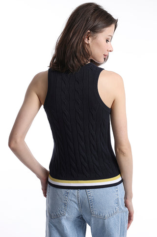 The back of model wearing navy cable knit sweater tank top with yellow, white and navy stripe detail on bottom hem