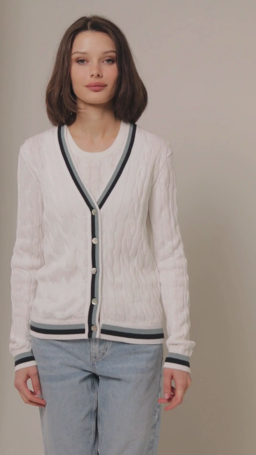 White cable knit cardigan with blue and black stripes on the hem 360 view