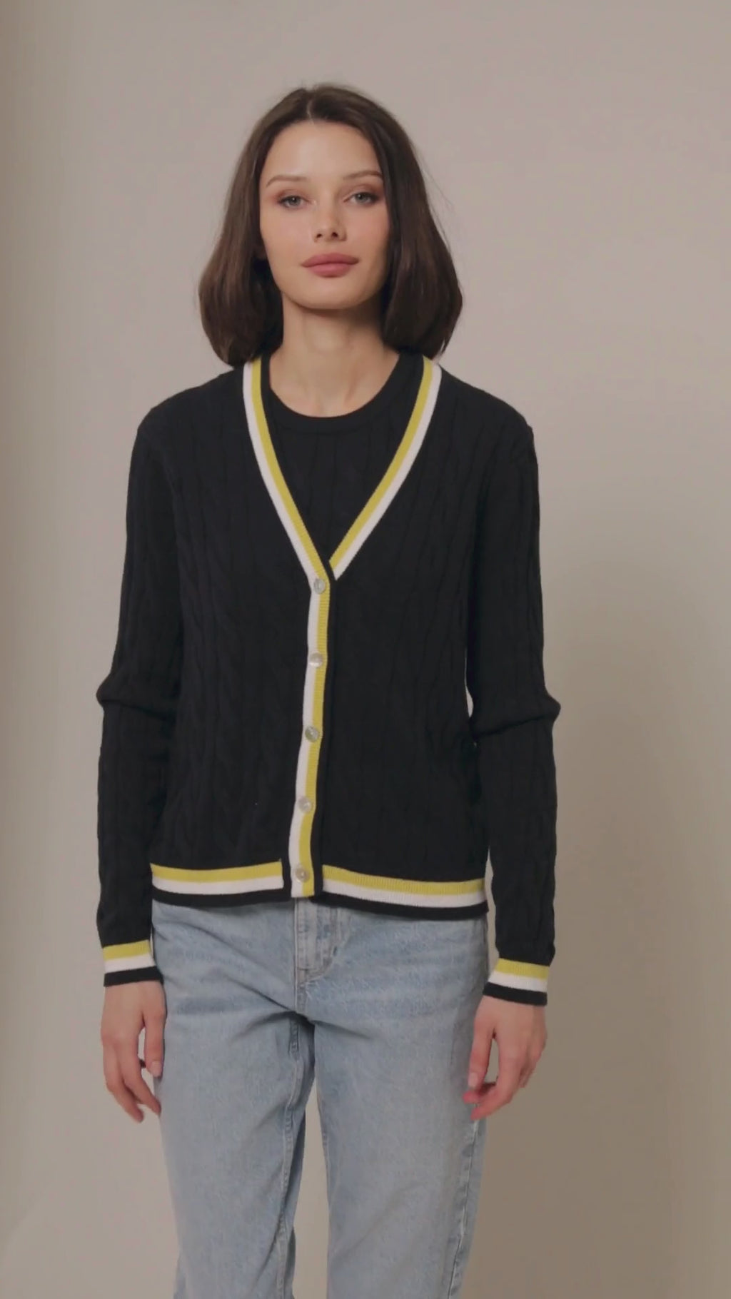 Navy cable knit cardigan with white and yellow stripes on the hem